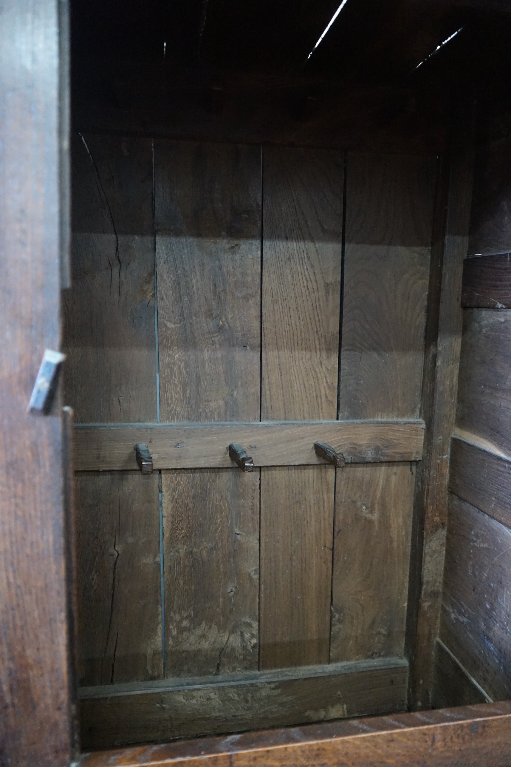 An 18th century panelled oak press cupboard, width 140cm, depth 56cm, height 185cm